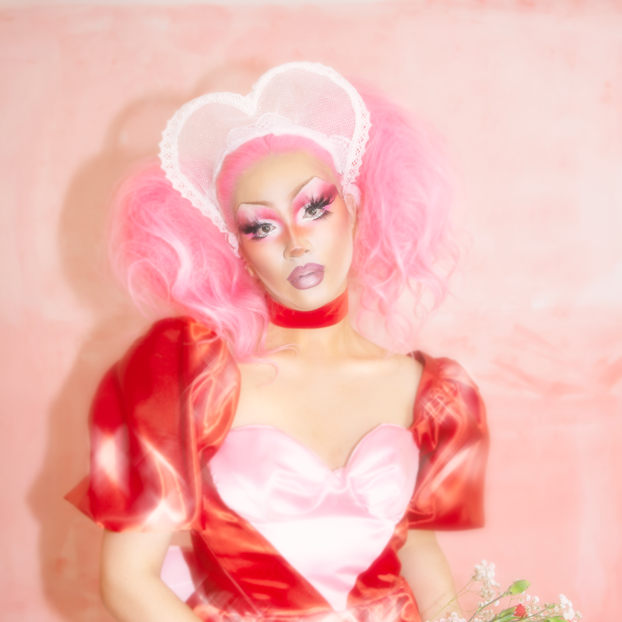 Third Kylie, Drag Queen aus Zürich in einem Kostüm zum Valentinstag mit Blumen in der Hand
